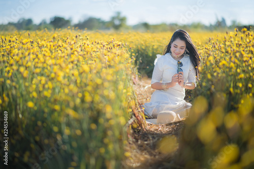 pretty woman in the white dress at yellow flowers field