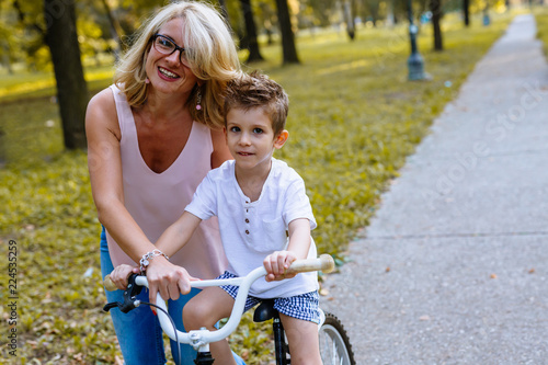First steps is always hard. woman teaching son to drive a bike