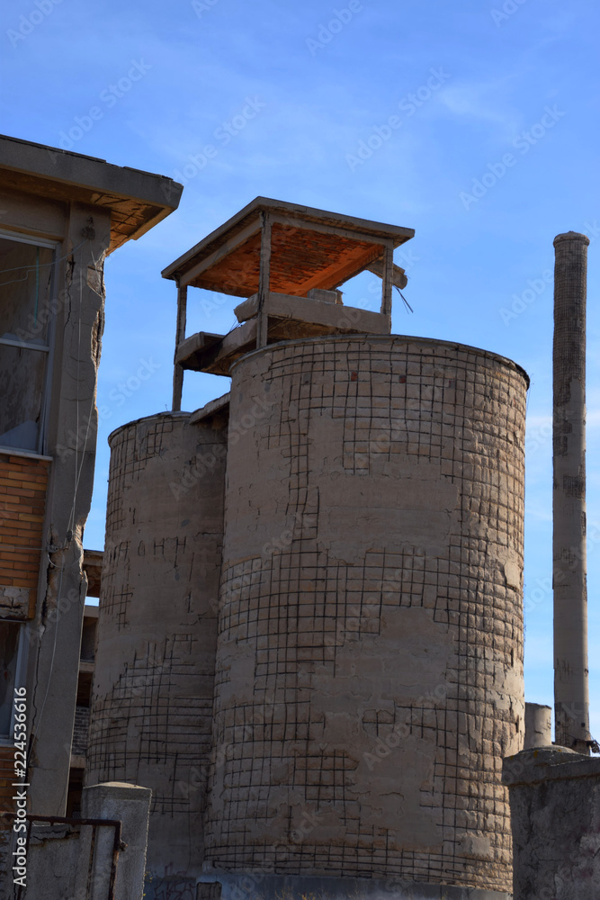 abandoned old factory area with towers and chimneys, old abandoned factory in sardinia, lost place factory facade