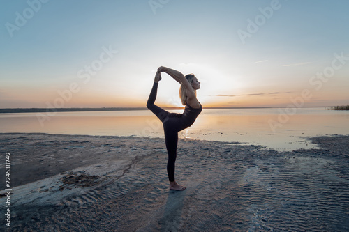 Girl practicing yoga at dawn