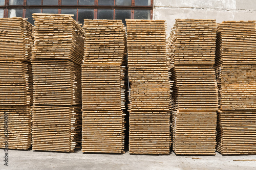 Piles of wooden boards in the sawmill  planking. Warehouse for sawing boards on a sawmill outdoors. Wood timber stack of wooden blanks construction material. Industry.