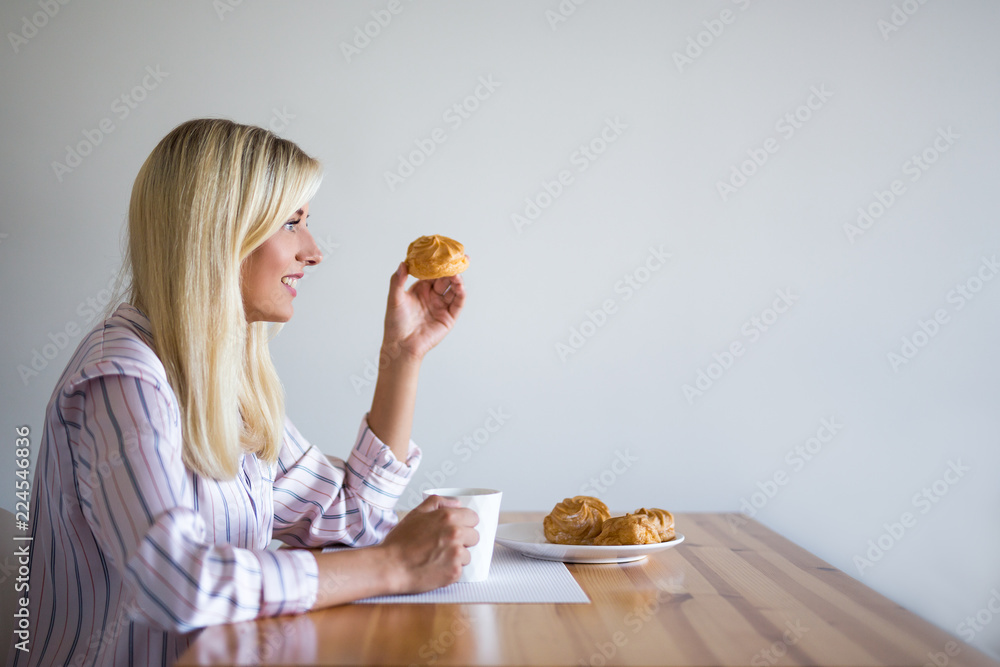 Fototapeta premium breakfast or coffee break concept - woman drinking coffee with pastry at home