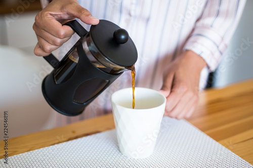 close up of woman pouring coffee from french press