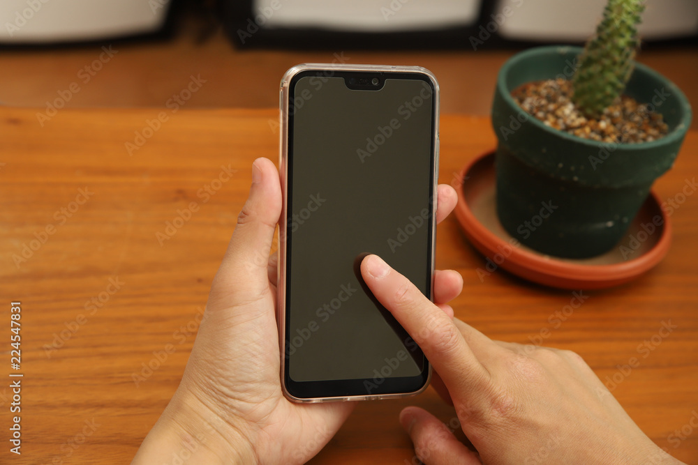 スマホをタッチする女性の手と観葉植物が置かれた木目の机 Stock Photo Adobe Stock スマホをタッチする女性の手と観葉植物が置かれた木目の机 Stock Photo Adobe Stock