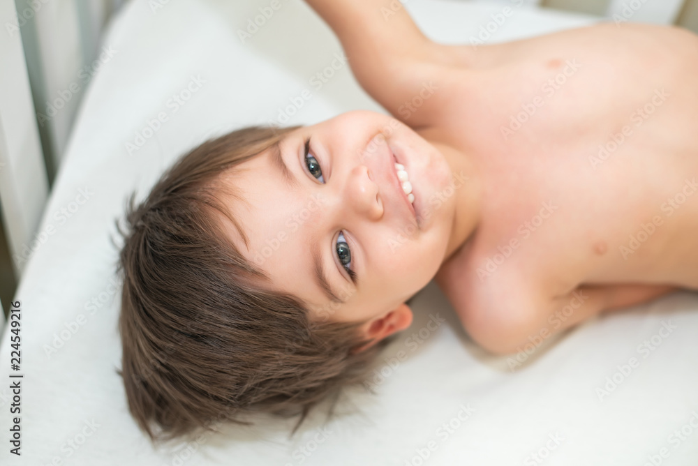 Cute baby boy toddler - in the crib - lying and smiling. Cute baby boy toddler - in the crib - lying and smiling.