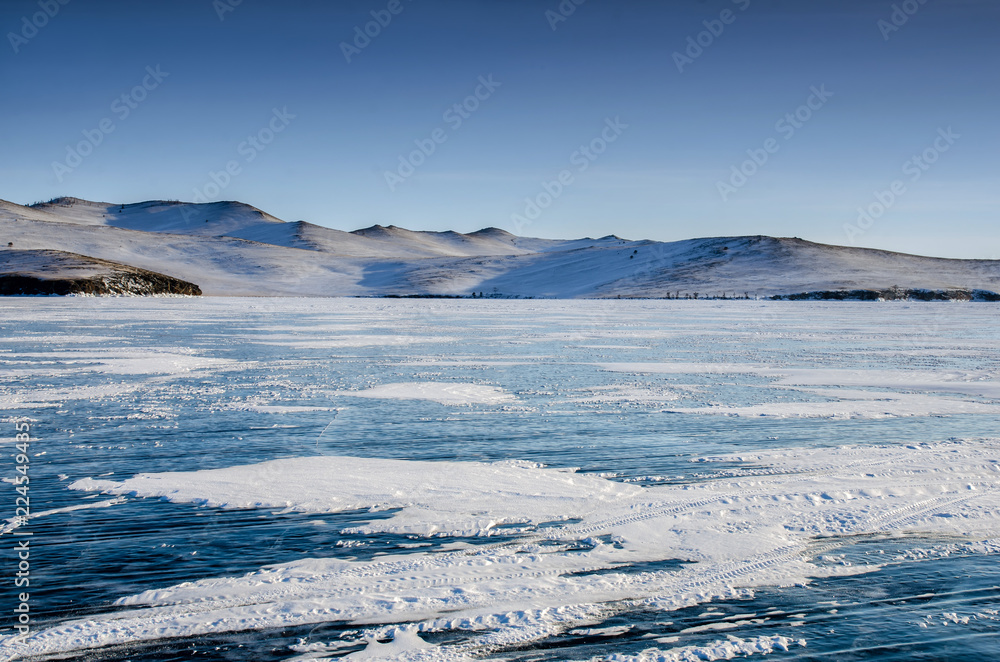 View of beautiful drawings on ice from cracks and bubbles of deep gas on surface of Baikal lake in winter, Russia View of beautiful drawings on ice from cracks and bubbles of deep gas on surface of Baikal lake in winter, Russia