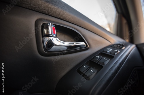 Closeup of a Door Control Panel and Handle in a Modern Car
