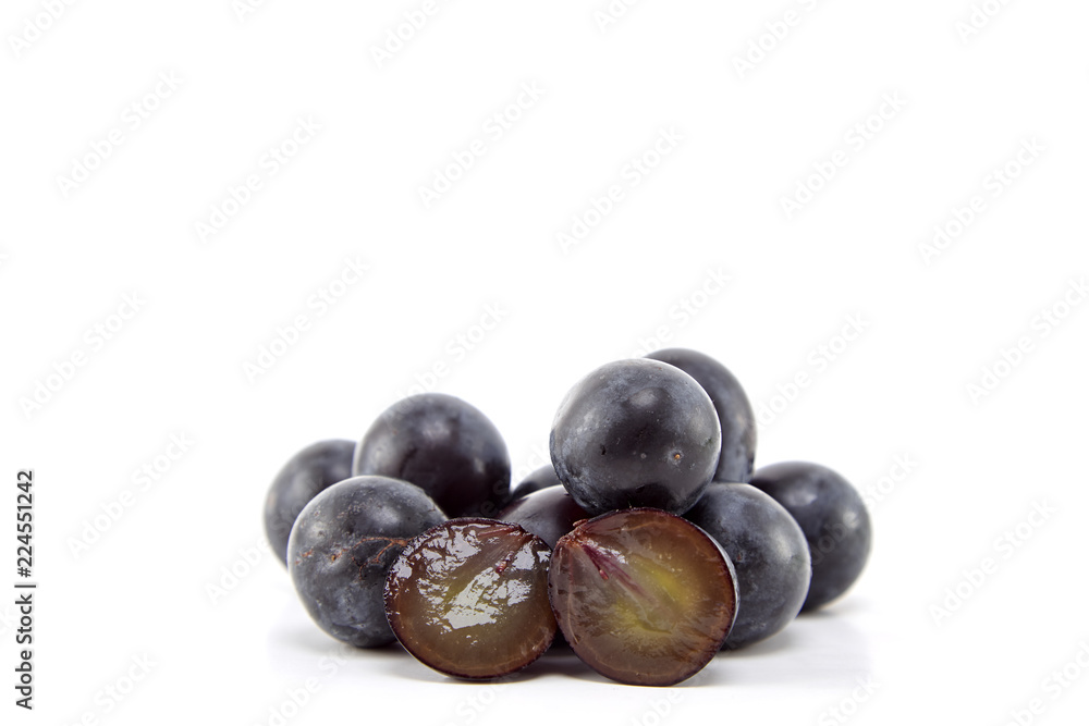 Fresh black grapes on white