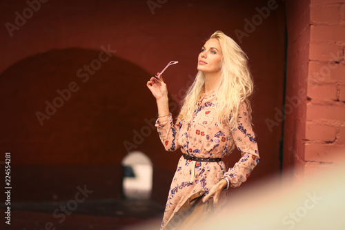 beautiful blond tourist woman with sun glasses in floral print dress photo