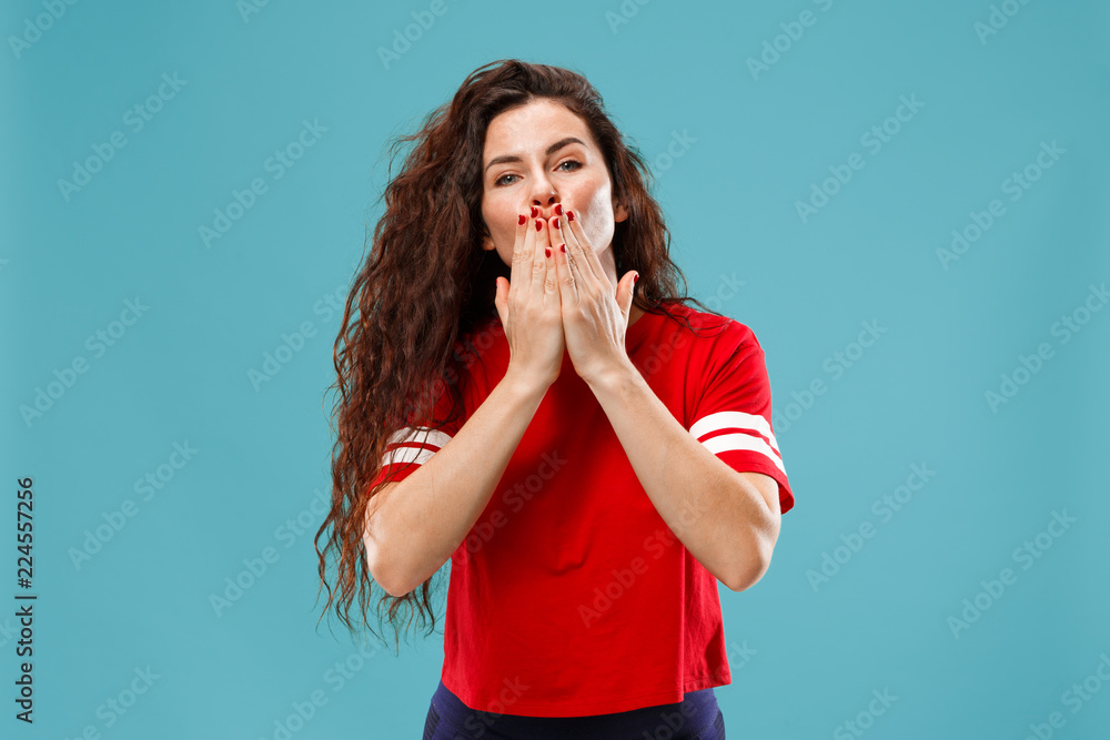 Happy business woman standing and kissing isolated on blue studio background. Beautiful female half-length portrait. Young emotional woman. The human emotions, facial expression concept. Happy business woman standing and kissing isolated on blue studio background. Beautiful female half-length portrait. Young emotional woman. The human emotions, facial expression concept.