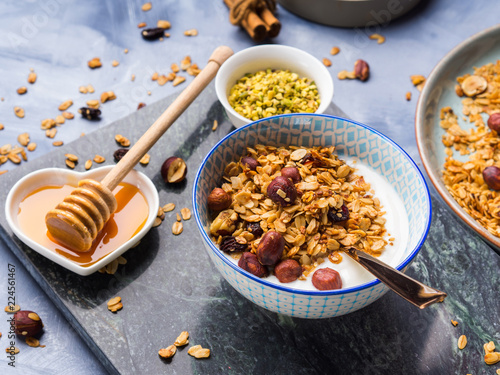 Yogurt bowl with homemade granola with chestnuts and honey served on marble board