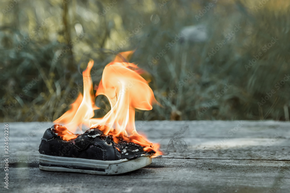 Creative background, burning shoes on a wooden background. The concept of  sweat feet, bad smell, spoiled shoes after long use. Stock Photo | Adobe  Stock