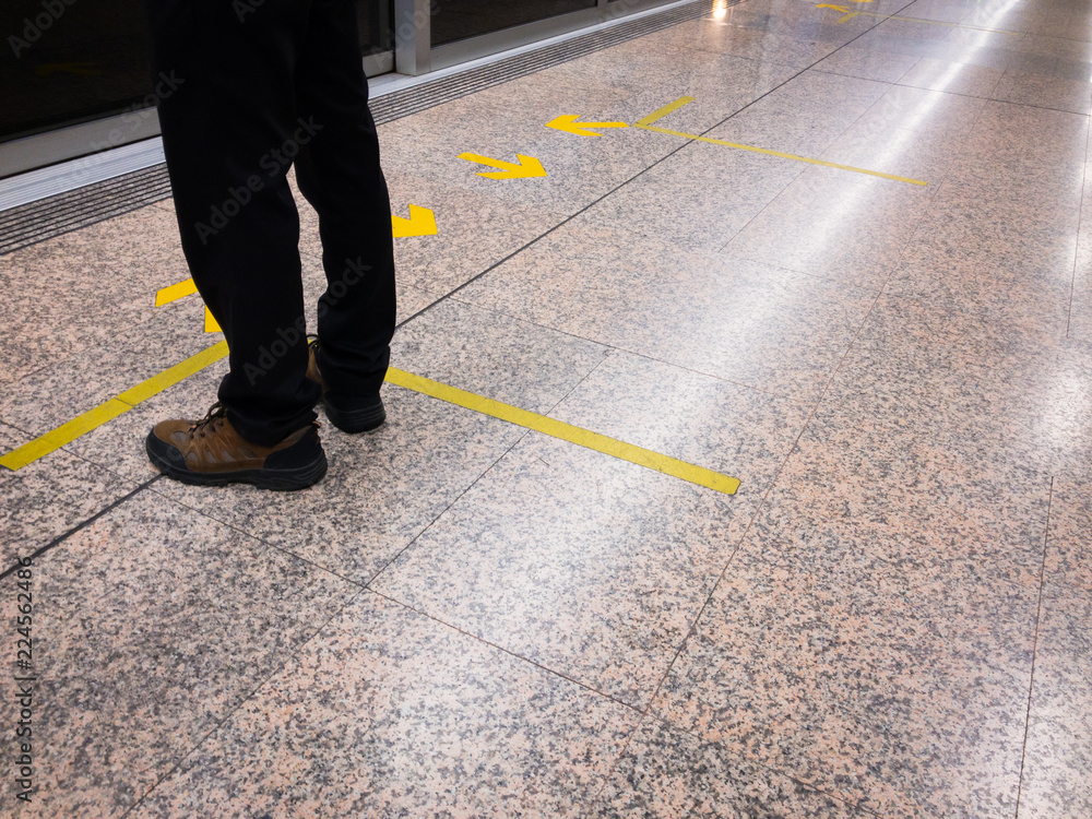 Man standing in front of the rail door and yellow arrow sign. Man standing in front of the rail door and yellow arrow sign.