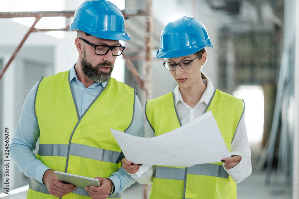 Engineers in hardhats have conversation Engineers in hardhats have conversation