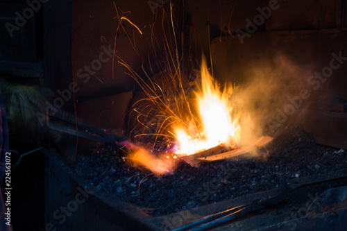 Blacksmith forging iron in workshop