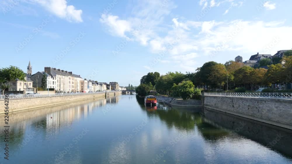 Buildings are reflected on the Sarthe River in the city of Le Mans in western France. Le Mans is an important city in the Pays de la Loire region. Filmed during the summer, sky with some clouds. Buildings are reflected on the Sarthe River in the city of Le Mans in western France. Le Mans is an important city in the Pays de la Loire region. Filmed during the summer, sky with some clouds.