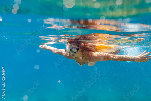 Beautiful woman underwater snorkeling in the clear tropical water