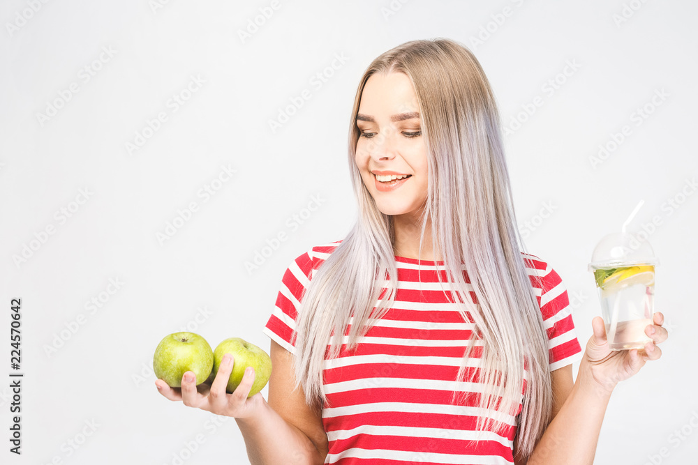 Portrait of young beautiful woman holding in hands glass of water and fresh green apple isolated over white. Portrait of young beautiful woman holding in hands glass of water and fresh green apple isolated over white.
