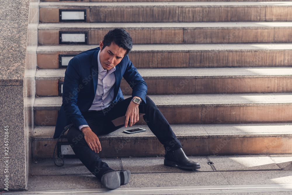Businessman making mistake about financial business. Exhausted and tired worker surrendering to fatigue working with headache sit down on the stairs, Businessman making mistake about financial business. Exhausted and tired worker surrendering to fatigue working with headache sit down on the stairs,