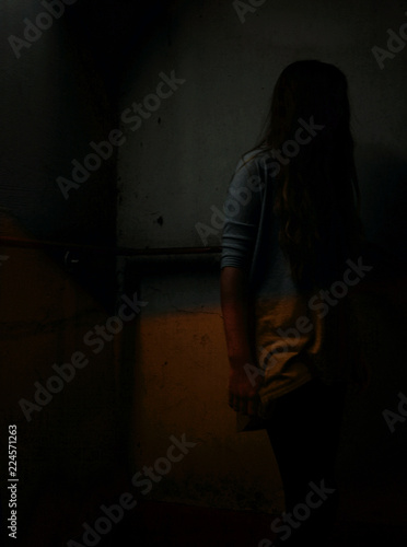 Young girl hiding in the shadows