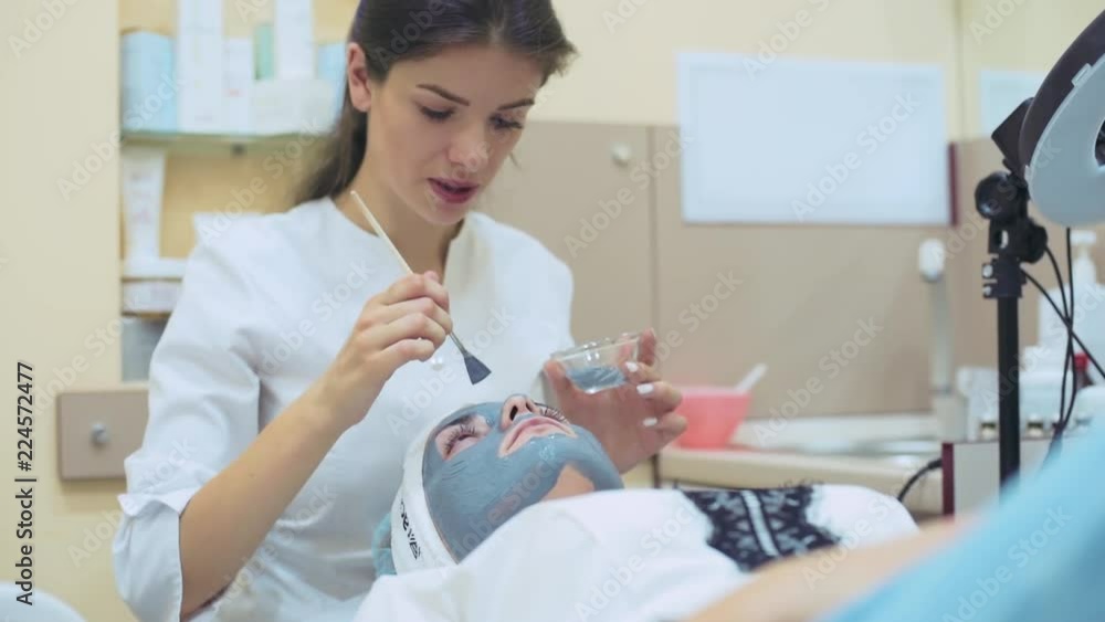 Woman cosmetologist applying mask on female`s face in beauty clinic. Skin treatment. Woman cosmetologist applying mask on female`s face in beauty clinic. Skin treatment.