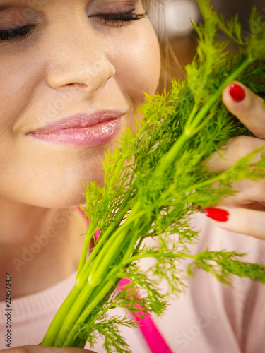 Young woman holding dill herb