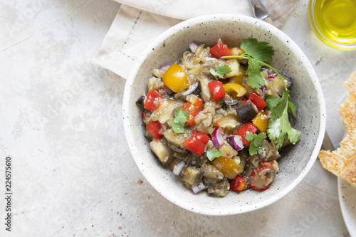 Cuadro en lienzo Vegetarian salad with baked aubergines, paprika, tomatoes, sweet red onion, oil and cilantro