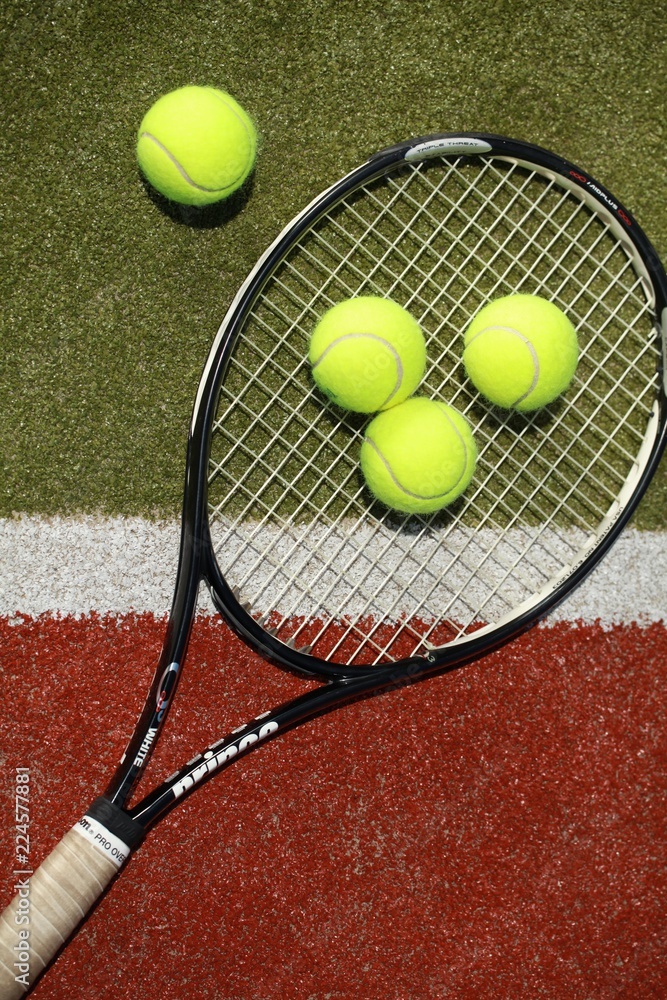 Tennis racket and tennis balls on a tennis court