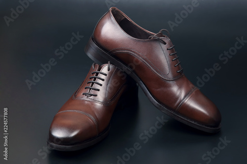 Classic men's brown Oxford shoes on dark background