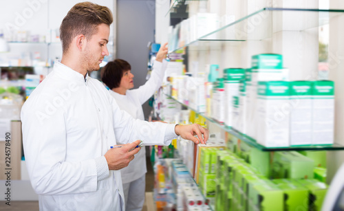 Man pharmacist standing among shelves
