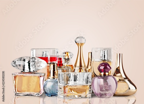 Aromatic perfume bottles on table on blurred