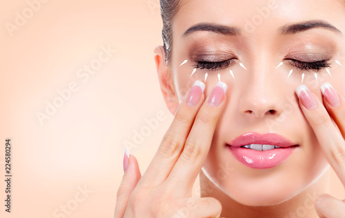 Pretty young woman massaging her face. Antiaging concept