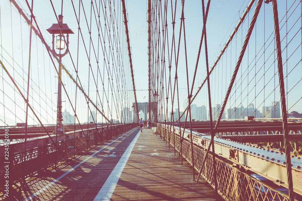 Naklejka premium Vintage Color View z Brooklyn Bridge ze szczegółami dźwigarów i kabli nośnych, Manhattan City Skyline at Sunrise, Nowy Jork, Nowy Jork, USA