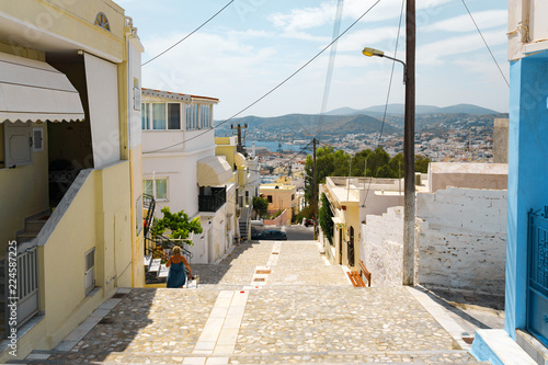 Сozy narrow streets of the old resort European town in a summer sunny day. Low-rise buildings of local residents, small cafes and hotels. Ermoupolis town on Syros island, Cyclades, greece.