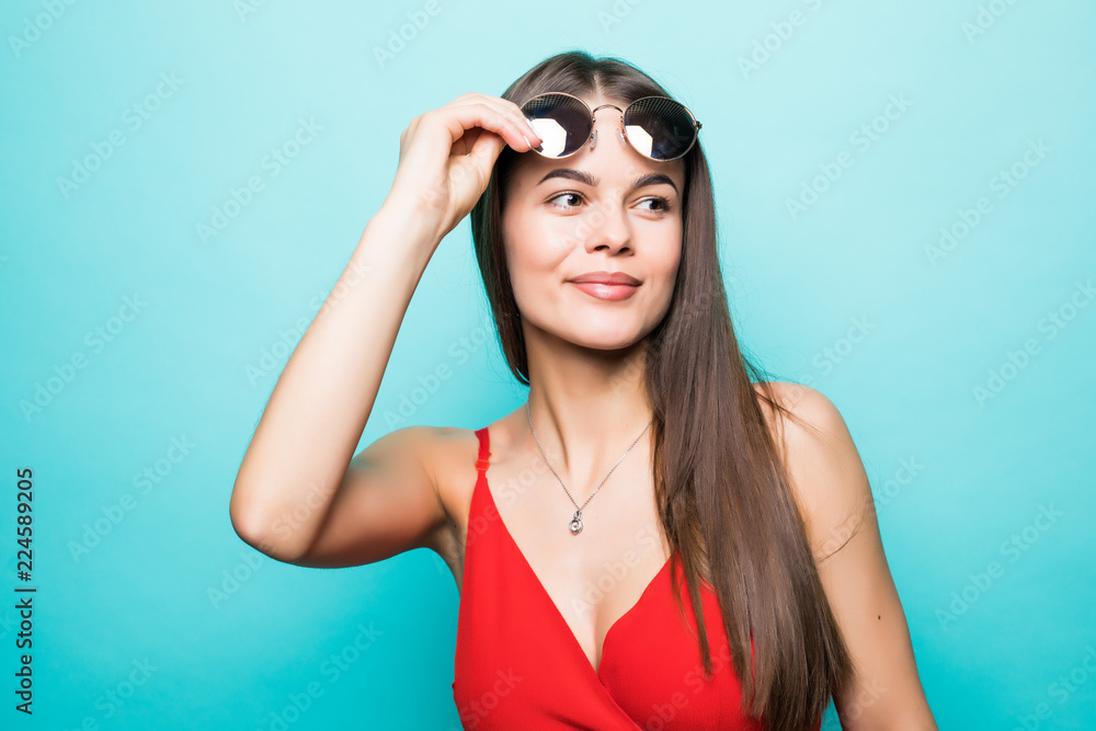 Portrait of a beautiful young girl in sunglasses on a blue background Portrait of a beautiful young girl in sunglasses on a blue background