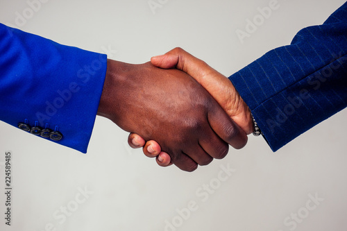 Portrait of two businessmen shaking hands in a business meeting on white background in studio shot