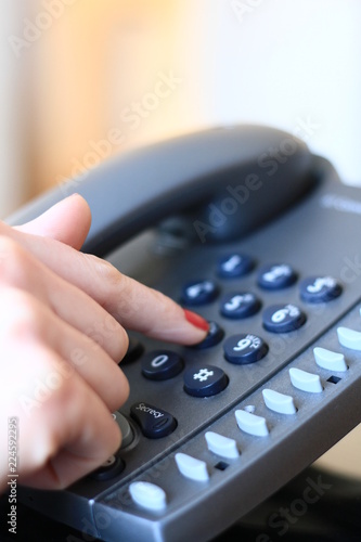 Receptionist dialing a number stock photo