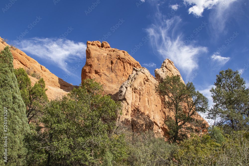 Garden of the Gods in Colorado Springs - huge red rock bluffs jut upwards against dramatic blue sky with whispy clouds