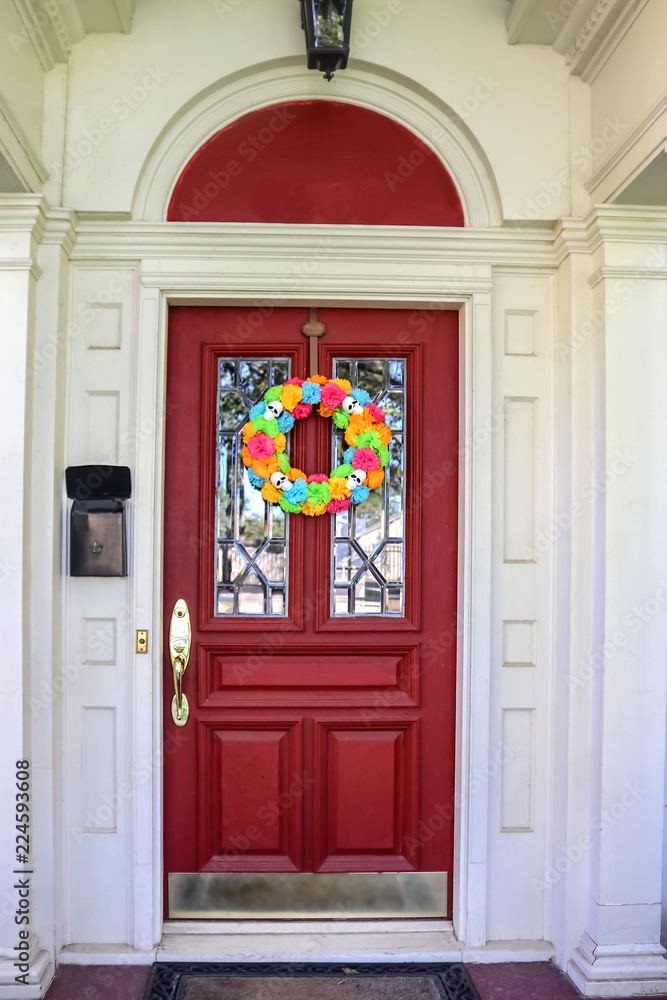 Resentails red front door with leaded glass in white house colorful Day of the Dead Halloween wreath Resentails red front door with leaded glass in white house colorful Day of the Dead Halloween wreath