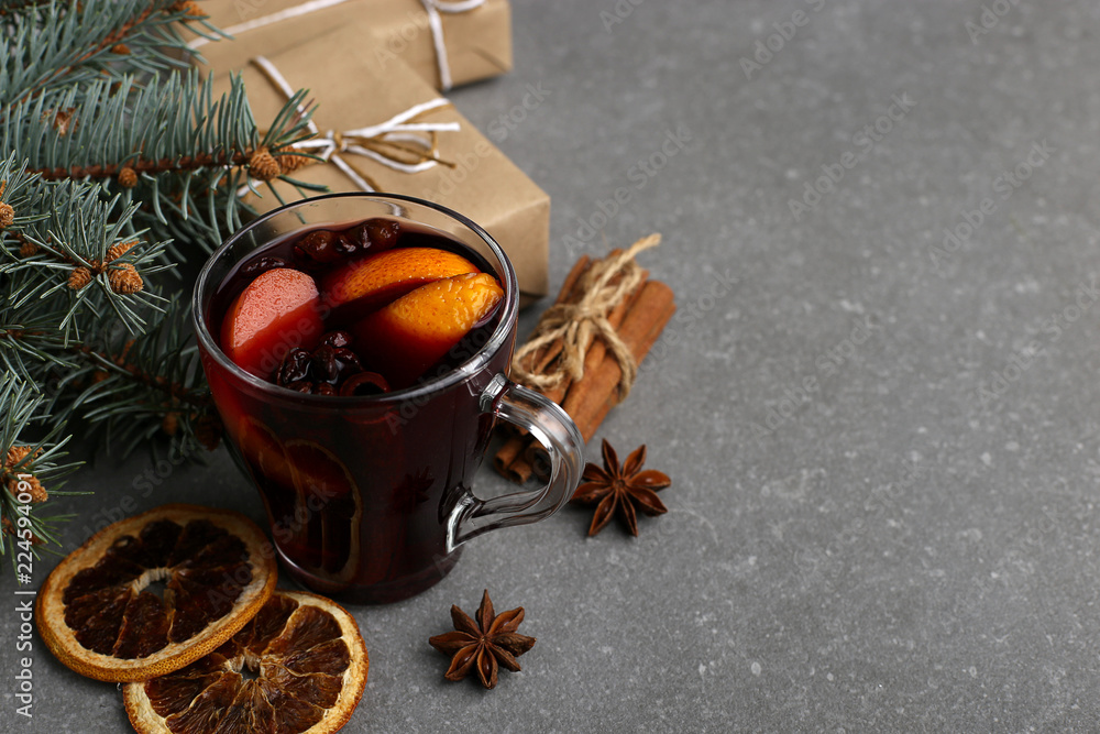 Mulled wine, a gift and spices on the table next to the tree. The concept of Christmas and New Year, decor.