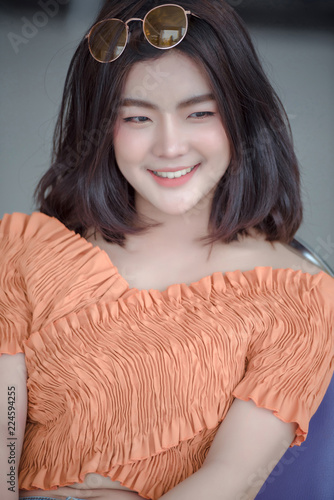 young beautiful stylish woman walking in pink coat, holding purse in hands, smiling, happy, street style, spring summer trend, black skirt, white shirt, flirty