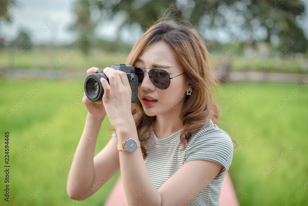 Outdoor summer smiling lifestyle portrait of pretty young woman having fun in the city in Europe in evening with camera travel photo of photographer