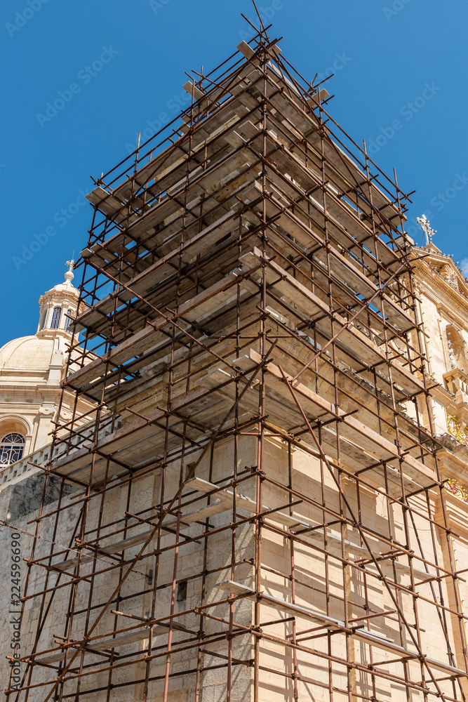 Construction scafold to restore church limestone.  Malta. Vertical.
