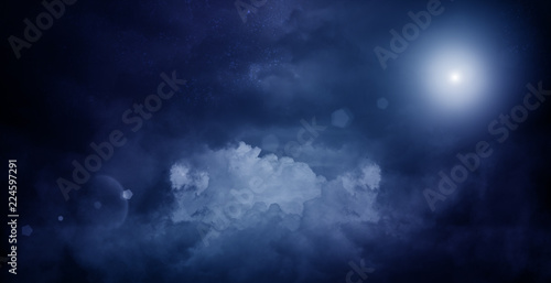 Abstract dark background of a night sky with clouds, a glow of the moon. The background of the storm sky