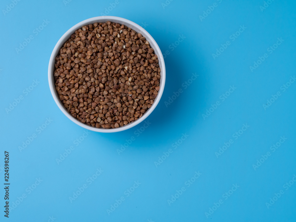 buckwheat in white cup on a blue background buckwheat in white cup on a blue background