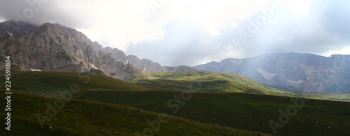 fantastic mountain panoramic image with clouds and rays of sun light, natural landscape photo