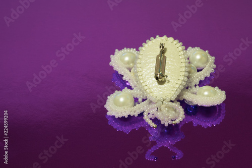 Brooch butterfly handmade from white beads, white artificial pearls and two zircons. The reverse side of the clasp