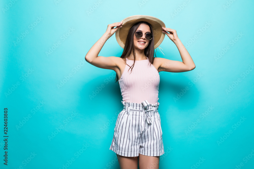 Portrait of pretty woman in sunglasses and hat over blue colorful. Summer concept. Portrait of pretty woman in sunglasses and hat over blue colorful. Summer concept.