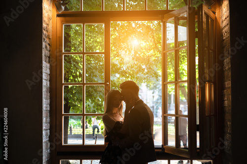 Young couple in love standing by the window