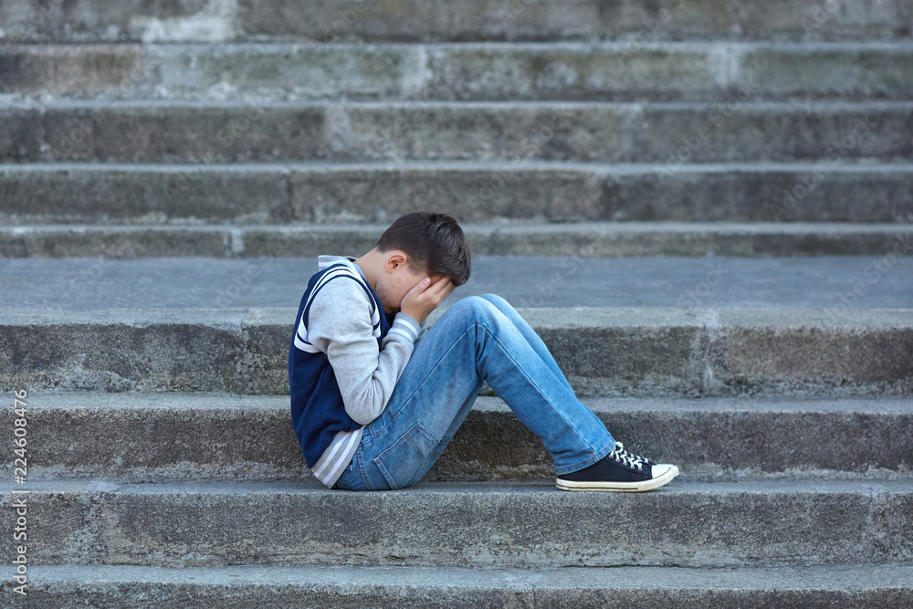 Schoolboy crying in the yard of the school Schoolboy crying in the yard of the school